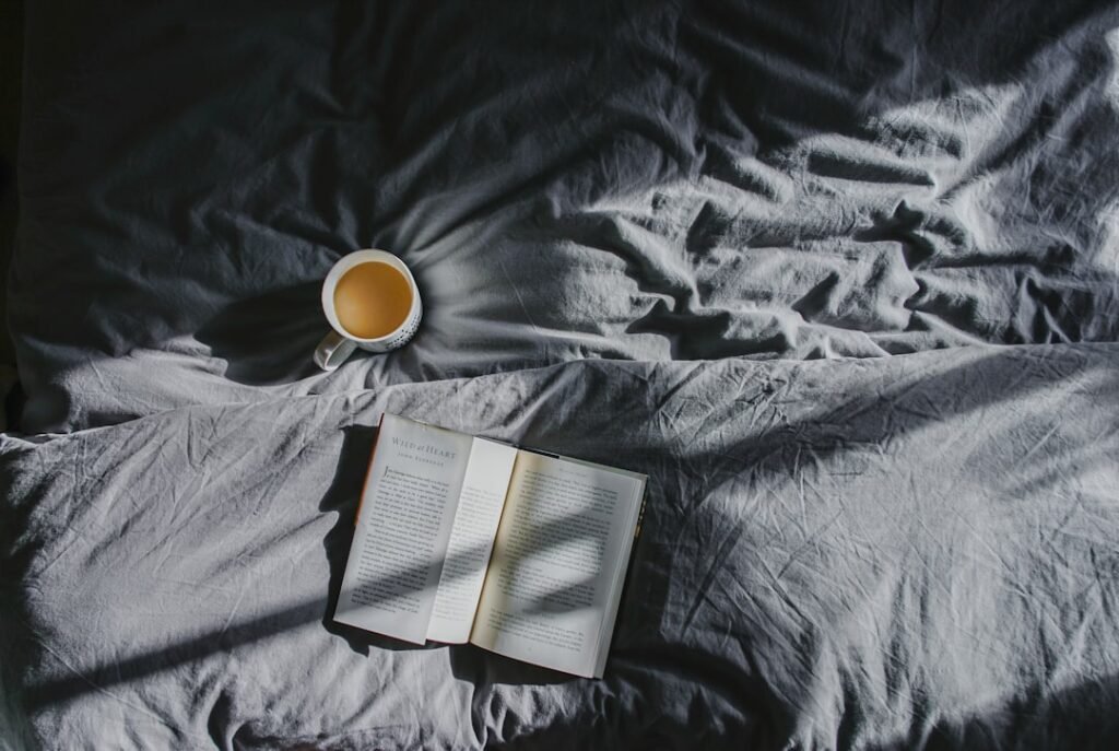 A warm cup of tea beside a book in quiet morning light