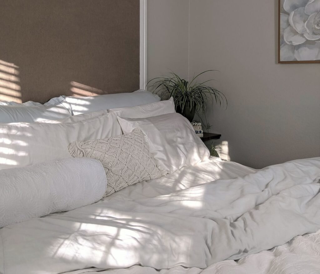 Cozy warm-toned bedroom with soft white linens, reflecting a calm wind-down atmosphere