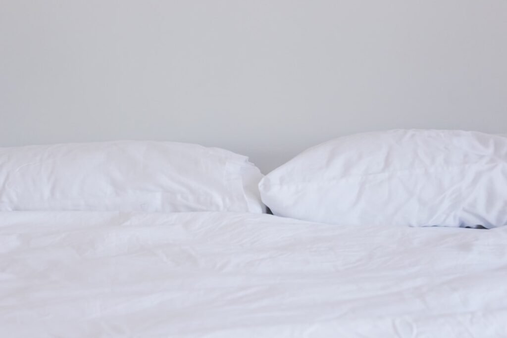 Stack of soft pillows in warm tones, representing the search for a comfortable sleep setup