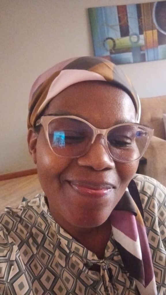 Jane smiling in a patterned head wrap and glasses, taken the day she arrived home from hospital on October 17.